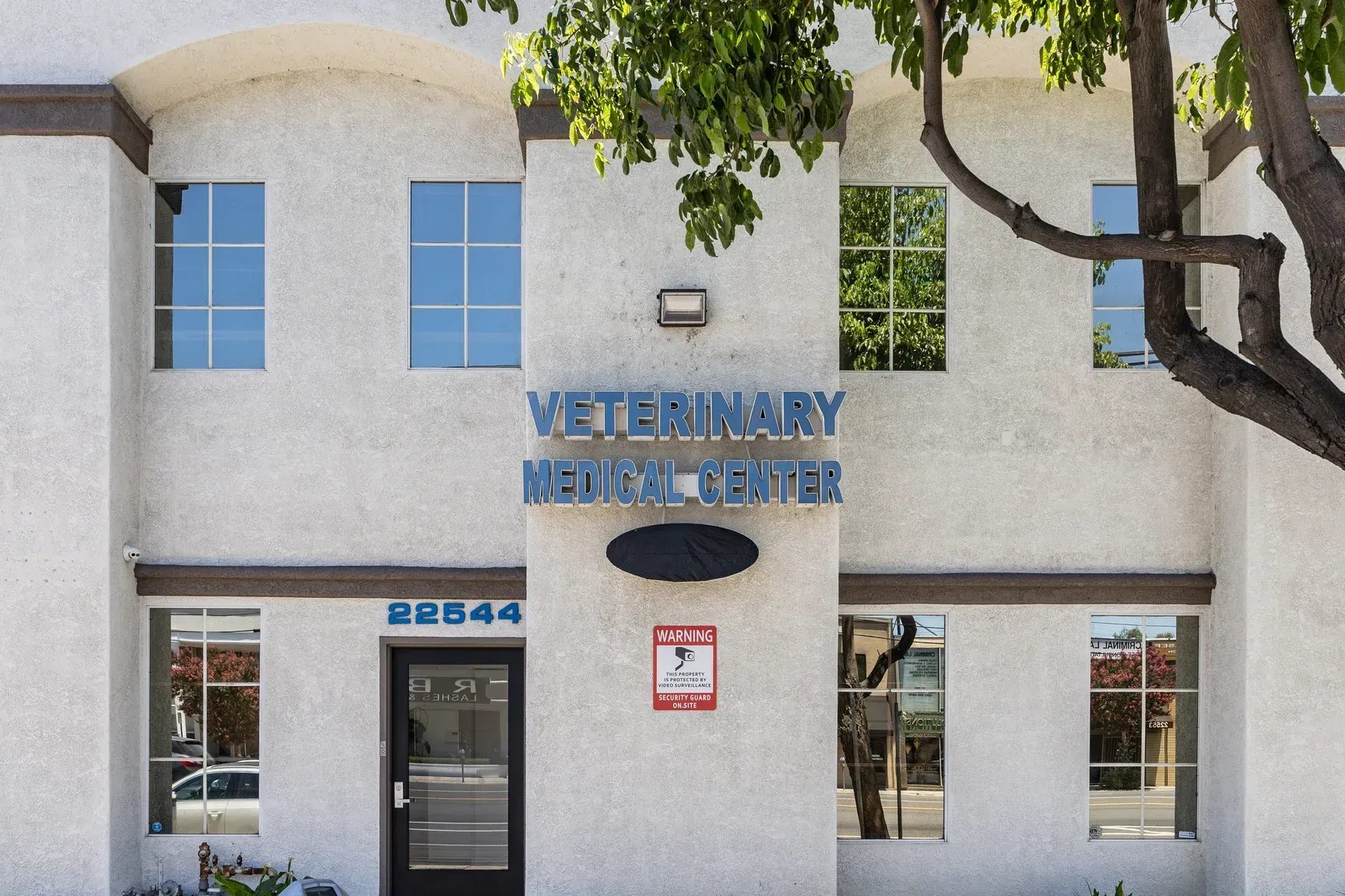 Exterior of Veterinary Medical Center of Woodland Hills building with blue signage and tree
